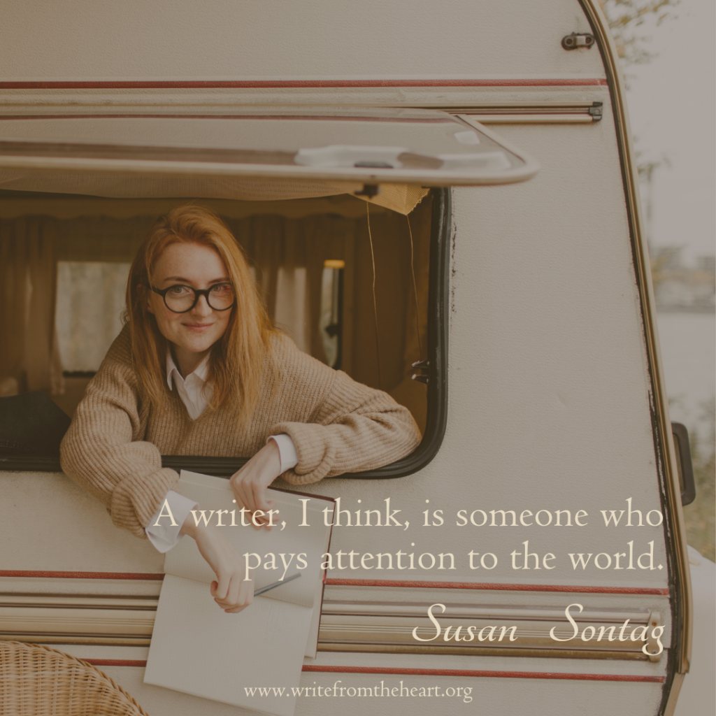 A young red-haired woman with glasses holding a notebook and pencil leaning out the window of a camper. The quote "A writer, I think, is someone who pays attention to the world" by Susan Sontag is in the lower right corner of the image.